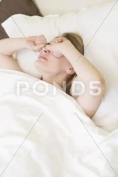 Young woman rubbing her eyes Stock Photos