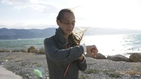 Young woman running and checking her cardio training data on her sport watch. Stock Footage