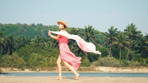 Young woman running in a pink swimsuit against the backdrop of tropical jungles Stock Photos