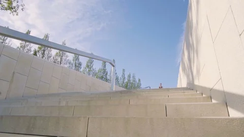 Young woman running on stairs in the park. Slow motion Stock Footage