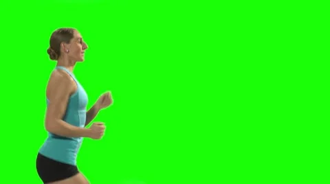 Young woman running on the treadmill in front of green screen. Profile Stock Footage