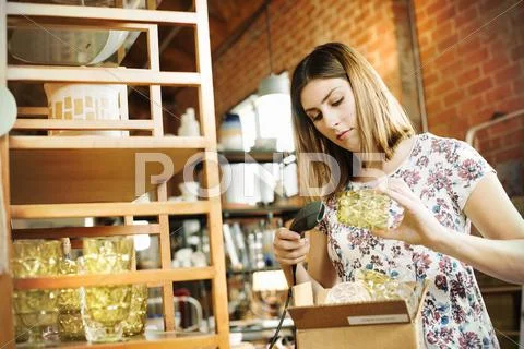 Young Woman Scanning The Barcode Of A Drinking Glass