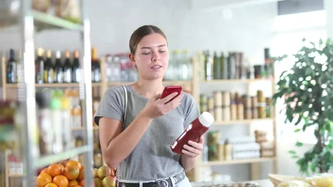 Young woman scanning qr code for ketchup Stock Footage 302722954