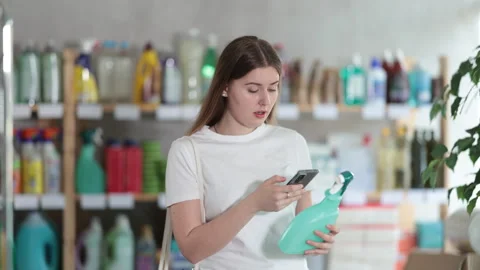 Young woman scanning qr code for cleaning spray Stock Footage 309540101