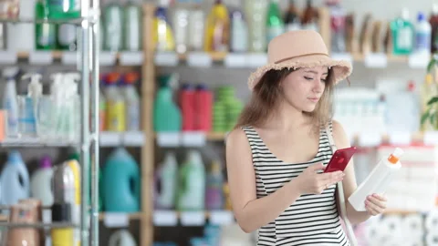 Young woman scanning qr code for sunscreen Stock Footage 310319834