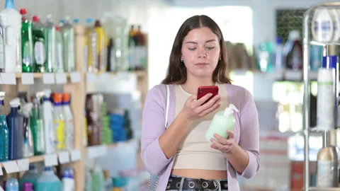 Young woman scanning qr code for liquid soap Stock Footage 311840547