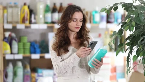 Young woman scanning qr code for shampoo or shower gel Stock Footage 312230900