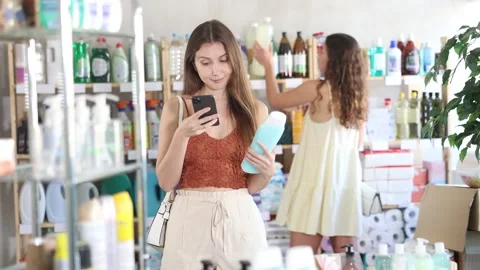 Young woman scanning qr code for shampoo Stock Footage 321339015