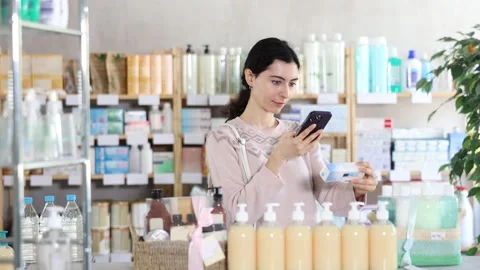 Young woman scanning qr code of ointment Stock Footage 331294177