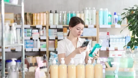 Young woman scanning qr code of mouthwash Stock Footage 332637967