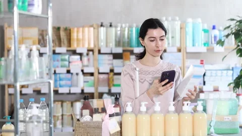 Young woman scanning qr code of cream Stock Footage 332736640