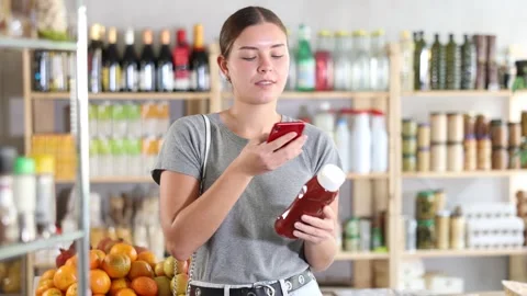 Young woman scanning qr code for ketchup 動画素材 341380041