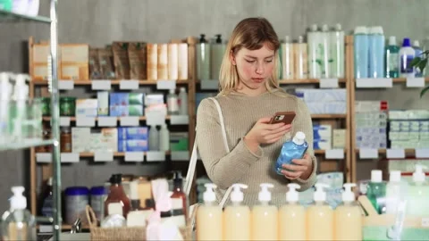 Young woman scanning qr code of mouthwash Vídeo Stock 344776123