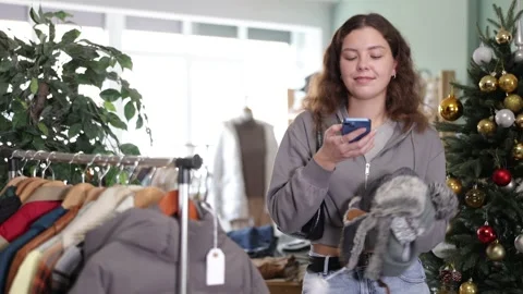 Young woman scanning qr code for hat in store Stock-Footage 346649202