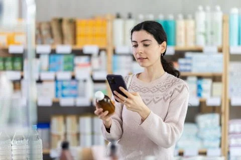 Young woman scanning qr code of syrup Foto stock
