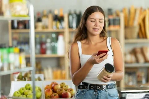 Young woman scanning qr code of beans Photos