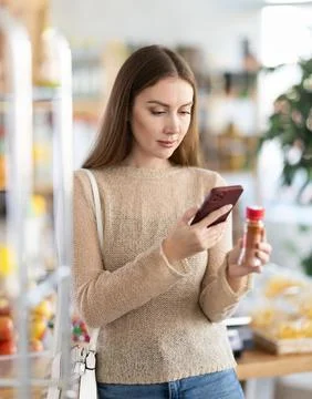 Young woman scanning qr code for ground pepper Stock-Fotos