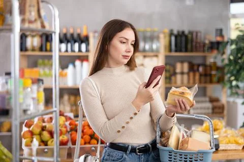 Young woman scanning qr code of cheese Foto stock