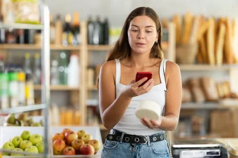 Young woman scanning qr code of cheese Stock Photos