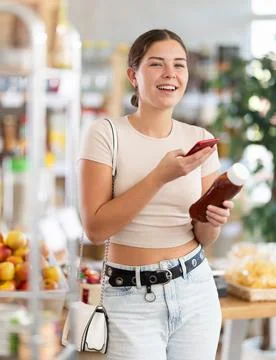 Young woman scanning qr code for ketchup Fotos de archivo