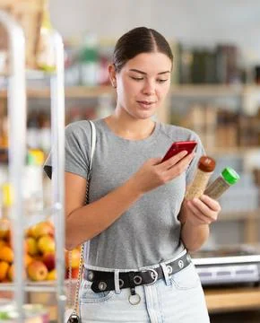 Young woman scanning qr code for seasoning herbs Fotos de archivo