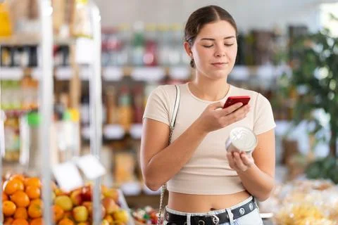 Young woman scanning qr code of canned food Fotos de archivo