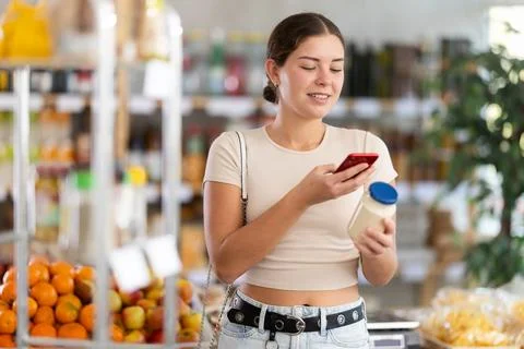 Young woman scanning qr code for mayonnaise Fotos de archivo