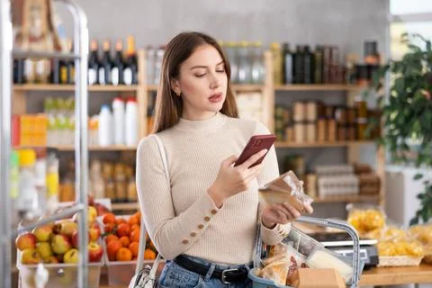 Young woman scanning qr code of cheese Fotos de archivo