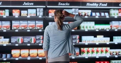 Young Woman Scratching Head While Deciding What Groceries To Buy Today. Stock Photos