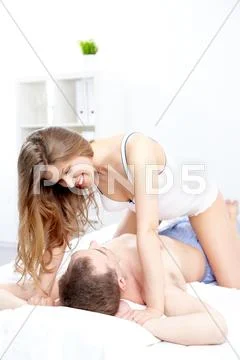 A young woman seducing a man in bed Stock Photos
