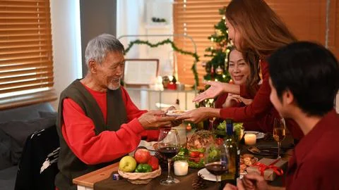Young woman serving delicious roasted turkey for Christmas party dinner with Stock Photos