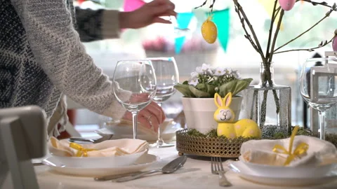 Young woman setting easter festive table with bunny and eggs decoration Stock Footage 86534244