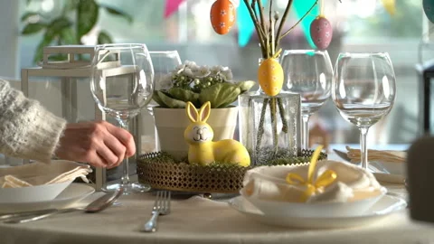 Young woman setting easter festive table with bunny and eggs decoration Stock Footage 86535753