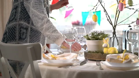Young woman setting easter festive table with bunny and eggs decoration Stock Footage 86537910