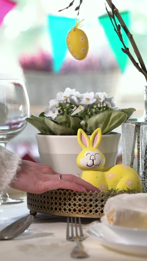 Young woman setting easter festive table with bunny and eggs decoration Stock Footage 263743272