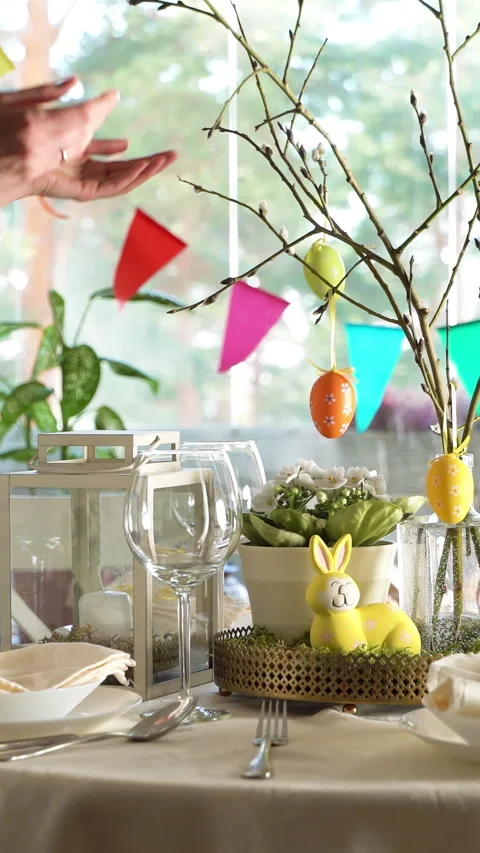 Young woman setting easter festive table with bunny and eggs decoration Stock Footage 263746131