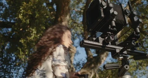 Young woman setting up large format camera in nature Stock Footage 117581460