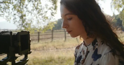 Young woman setting up large format camera in nature Stock Footage 117581518