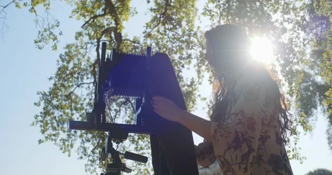 Young woman setting up large format camera in nature Stock Footage 117583952