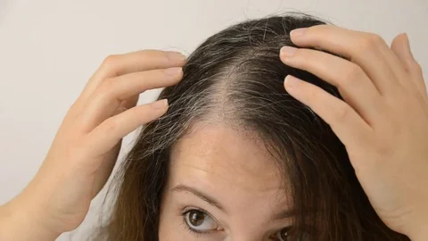 Young woman shows her gray hair Stock Footage