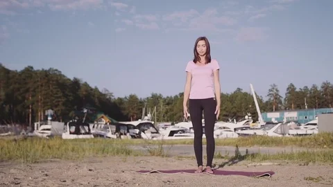 Young woman silhouette practicing yoga on the sea beach at sunset. Slim woman Stock Footage