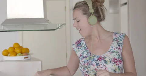 Young woman singing in with spoon while cooking slow motion Video stock 56064047