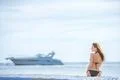The young woman sit against the background of the yacht Photo