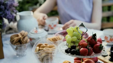 A young woman sits in the backyard at a table with ripe organic berries and Stock Footage 196901327