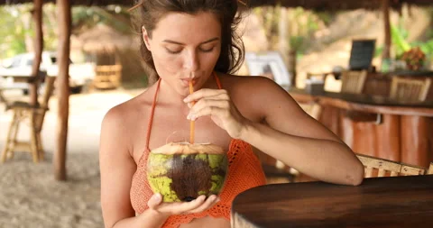 Young woman sitting in authentic beach bar with a coconut drink Stock-Footage 233644285
