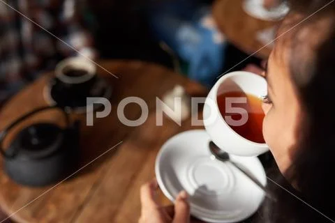 Young woman sitting in a cafe drinking tea Stock Photos