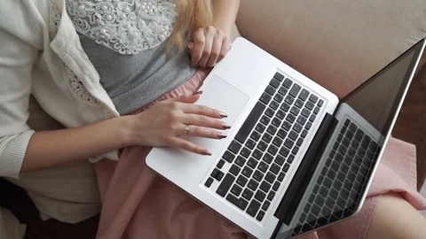 Young woman sitting on couch using laptop and smiling, Hands close-up. Fingers Stock-Footage 74445163