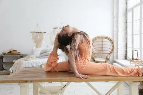 Young woman sitting down in a split position Stockfoto's