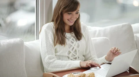 Young woman sitting on floor by window using laptop holding credit card  Stock Footage 34150053