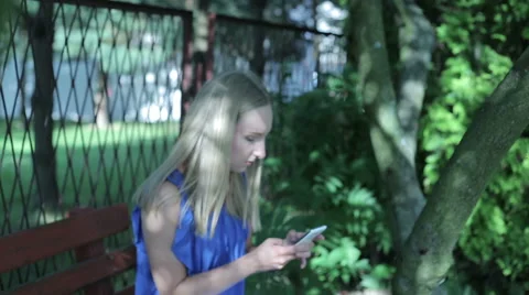 Young woman sitting outside texting Stock Footage 59141424